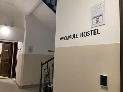 a sign for a castle hospital on the side of a building at Capsule hostel Žižkov tower in Prague