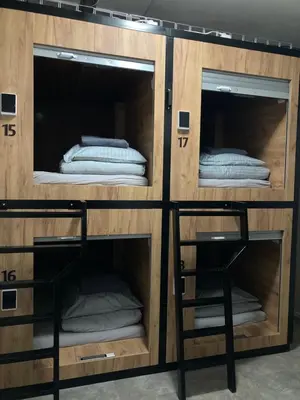 a wooden room with three bunk beds in it at Capsule hostel Žižkov tower in Prague