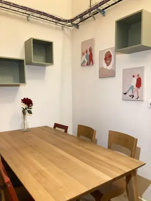 a dining room with a wooden table and chairs at Capsule hostel Žižkov tower in Prague