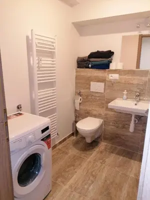 a bathroom with a washing machine and a sink at Brand new studio apartment #62 with free secure parking in the center in Prague