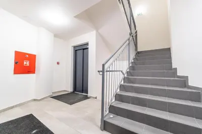 a staircase in a building with a red door at Brand new studio apartment #62 with free secure parking in the center in Prague