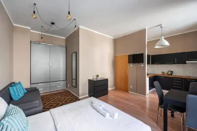 a living room with a couch and a kitchen at Vals Garden Apartment in Prague