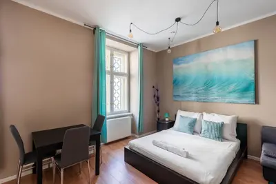 a bedroom with a bed and a desk and a table at Vals Garden Apartment in Prague