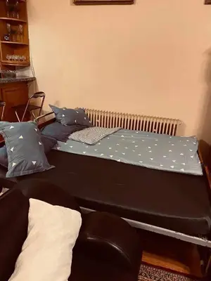 a bed with a blue sheet on top of it at soukromý apartmán Přemysl in Nymburk