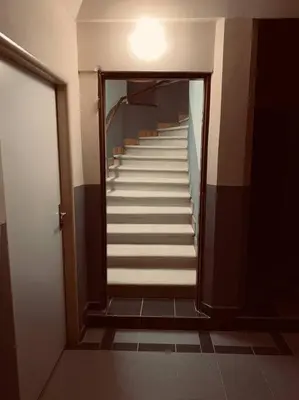 a hallway with stairs in a building with a light at soukromý apartmán Přemysl in Nymburk