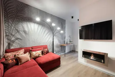 a living room with a red couch and a fireplace at New modern apartment 5. floor in Prague
