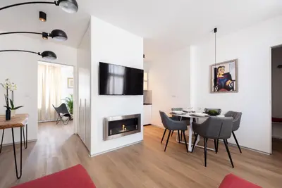 a living room with a dining room table and a fireplace at New modern apartment 5. floor in Prague