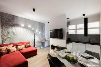a living room with a red couch and a table at New modern apartment 5. floor in Prague