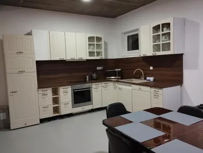 a kitchen with white cabinets and a table in it at Apartmány Svatá in Zdice