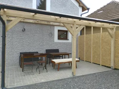 a wooden pergola with a table and chairs at Apartmány Svatá in Zdice