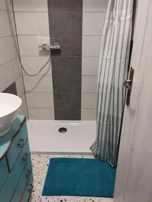 a bathroom with a shower with a tub and a shower rug at Apartmány Svatá in Zdice