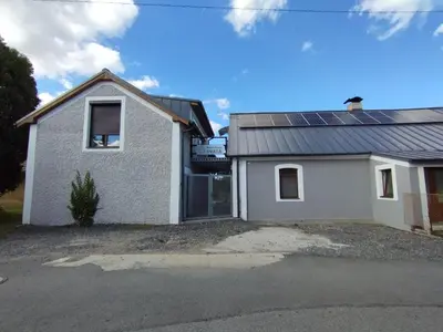 a white house with solar panels on the roof at Apartmány Svatá in Zdice