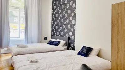 a bedroom with two beds and a wall with a window at Hotel Apartment in Prague 2 Square in Prague