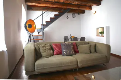 a living room with a couch and a staircase at Bohéme Apartments Old Town Square in Prague