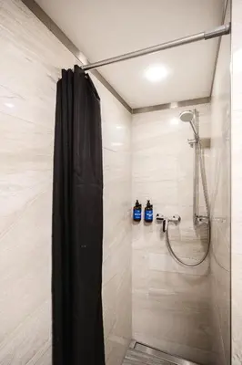 a shower with a black shower curtain in a bathroom at Prague Days - Modern Studios - 7 min Wenceslas Square in Prague
