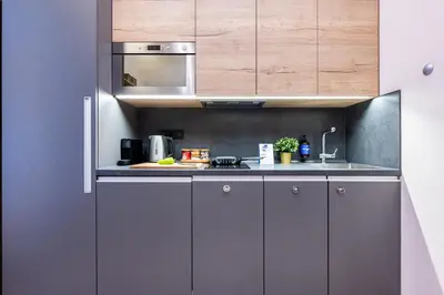 a kitchen with grey cabinets and a microwave at Prague Days - Modern Studios - 7 min Wenceslas Square in Prague