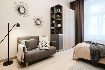 a living room with a chair and a bed at Prague Days - Modern Studios - 7 min Wenceslas Square in Prague