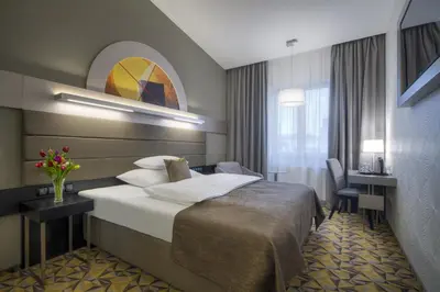 a hotel room with a bed and a desk at Hotel Essence in Prague