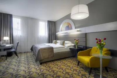 a hotel room with a bed and a yellow chair at Hotel Essence in Prague
