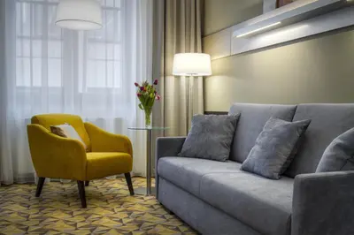a living room with a couch and a yellow chair at Hotel Essence in Prague