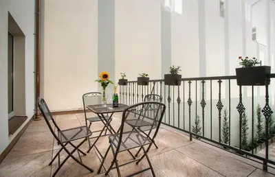 a balcony with a table and chairs on a fence at Hotel Essence in Prague