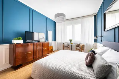a bedroom with blue walls and a bed and a tv at Bohéme Apartment Wenceslas Square in Prague