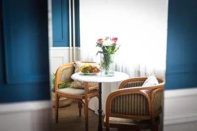a table with a vase of flowers and two chairs at Bohéme Apartment Wenceslas Square in Prague