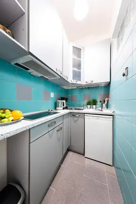 a kitchen with blue walls and white cabinets at Bohéme Apartment Wenceslas Square in Prague