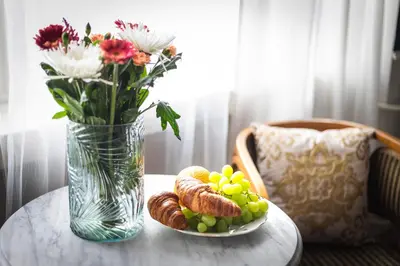 a table with a plate of bread and a vase with flowers at Bohéme Apartment Wenceslas Square in Prague
