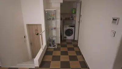 a hallway with a checkered floor and a washing machine at School Apartment - Your Unique Place in Prague by metro Vyšehrad in Prague
