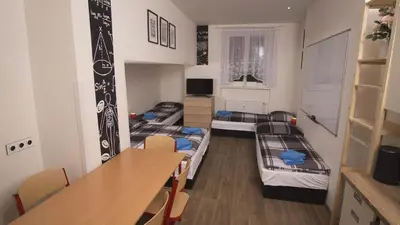 a room with three bunk beds and a table at School Apartment - Your Unique Place in Prague by metro Vyšehrad in Prague