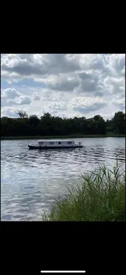 a boat in the middle of a body of water at Zouw Hausboat Zakotven -pouze ubytovaní in Roudnice nad Labem