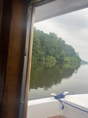 a bird sitting on the side of a boat on a river at Zouw Hausboat Zakotven -pouze ubytovaní in Roudnice nad Labem