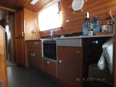 a kitchen with wooden cabinets and a stove top oven at Zouw Hausboat Zakotven -pouze ubytovaní in Roudnice nad Labem