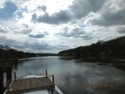 a boat is docked on a river on a cloudy day at Zouw Hausboat Zakotven -pouze ubytovaní in Roudnice nad Labem
