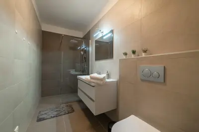 a bathroom with a toilet and a sink and a mirror at New apartments near Dancing house in Prague