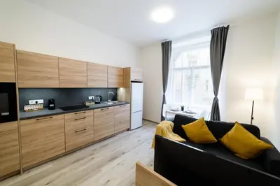 a living room with a couch and a kitchen at New apartments near Dancing house in Prague