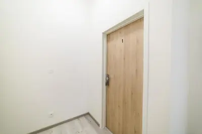 an empty room with a wooden door in the corner at New apartments near Dancing house in Prague