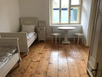 a bedroom with two beds and a table and a window at Dvůr bude in Osečany