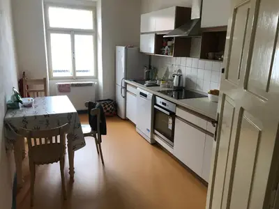 a kitchen with a table and a white refrigerator at Dvůr bude in Osečany