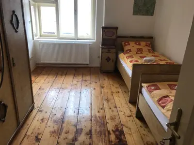 a bedroom with two beds and a wooden floor at Dvůr bude in Osečany