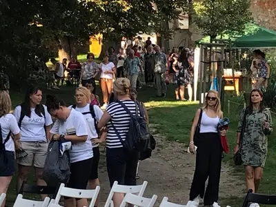 a group of people standing around in a park at Dvůr bude in Osečany