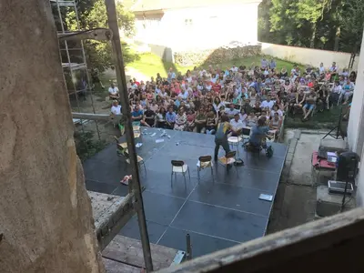 a crowd of people watching a man on a stage at Dvůr bude in Osečany