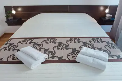 a white bed with two towels on it at Dlouha Apartment 2BD in Prague