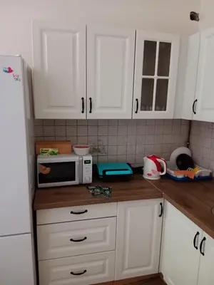 a kitchen with white cabinets and a microwave on a counter at Hostel Jasmin in Prague