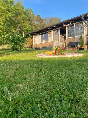 a blanket on the grass in front of a house at Glamping Karavan u Konopiště in Chrášťany