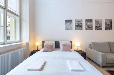 a bedroom with a large white bed and a couch at Luxury Apartment on Old Town Square in Prague