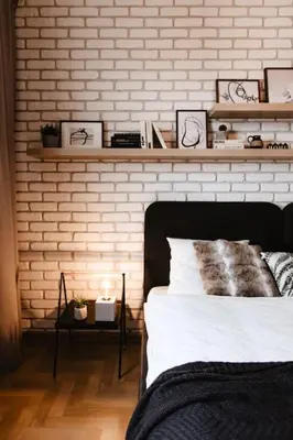 a bedroom with a white brick wall and a bed at Loft apartment with balcony in centre in Prague