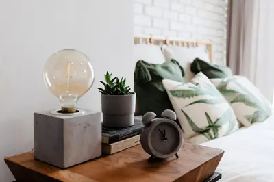 a table with a clock and a lamp on a bed at Loft apartment with balcony in centre in Prague