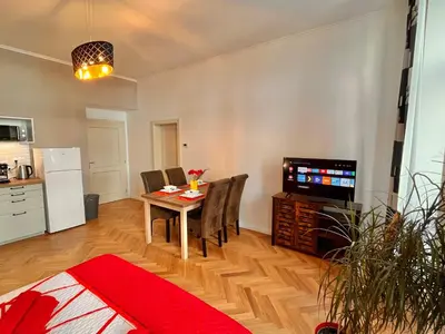 a living room with a table and a television at Riverbridge Apartments Prague in Prague